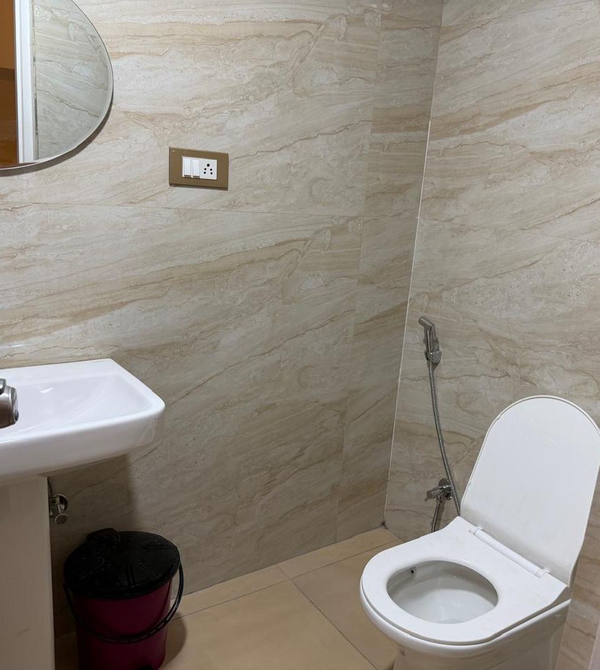 Bathroom with washbasin and western toilet at Zuza Homes, Hyderabad