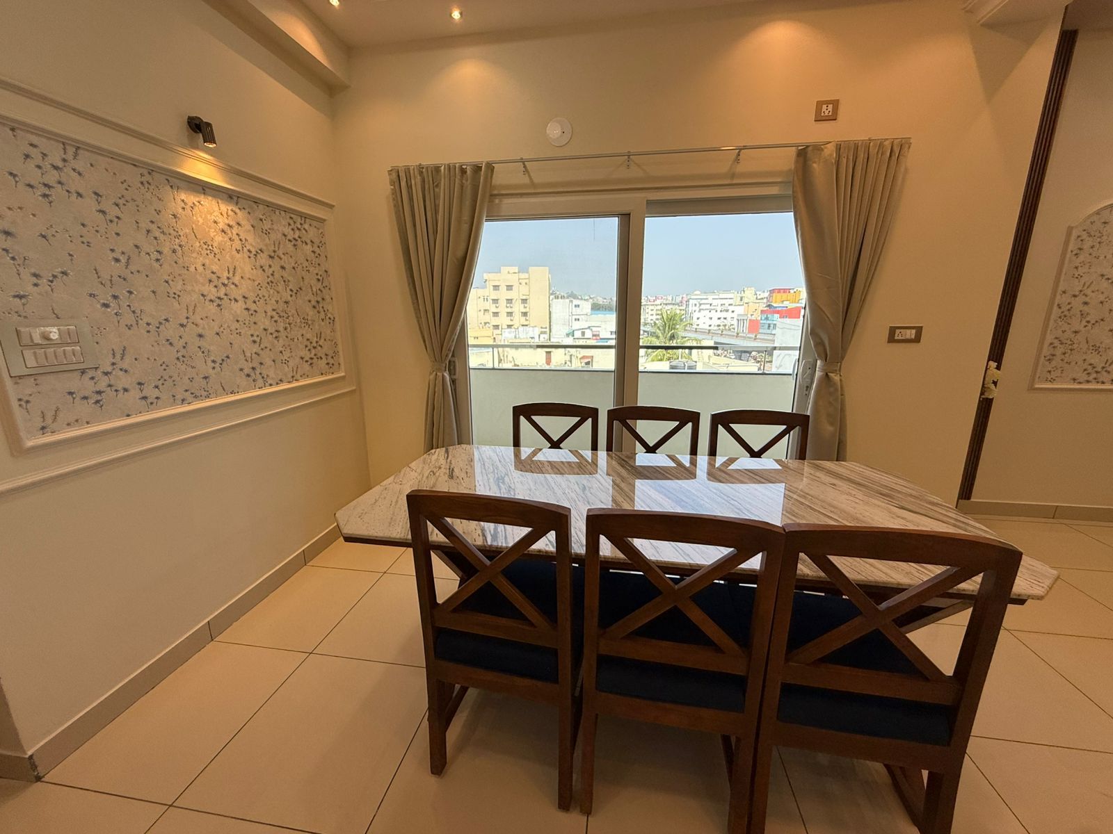 Six-seater dining table beside the balcony at Zuza Homes, Hyderabad